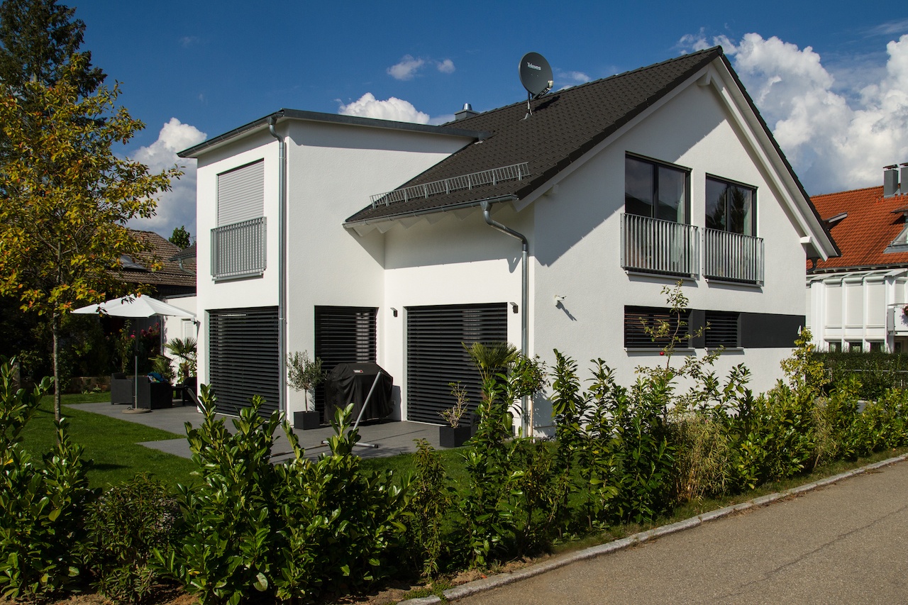  Einfamilienhaus mit anthrazitfarbigem Satteldach und klassischem Dachüberstand, Flachdachgaube und Erker